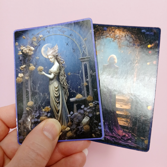 Two TCG cards with artistic designs of a woman and a landscape, held against a pink background. Samples of glossy laminate